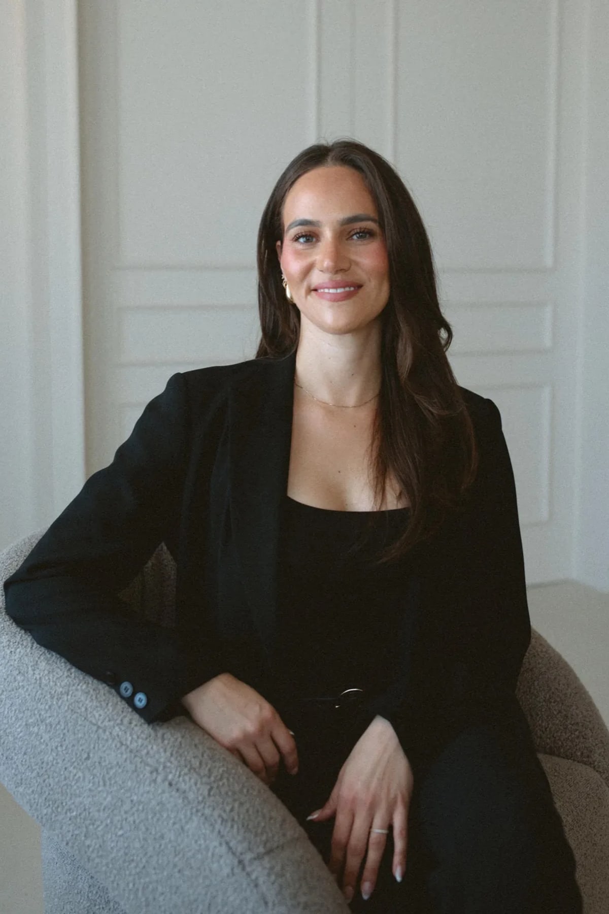 Daniella Simas Medeiros, Registered Psychotherapist (Qualifying), seated portrait in the Anchor & Bloom therapy office