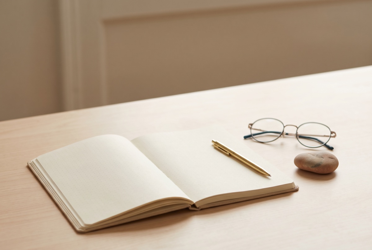 A notebook and pen resting on a desk, evoking the reflective, depth-oriented pace of psychodynamic therapy at Anchor & Bloom