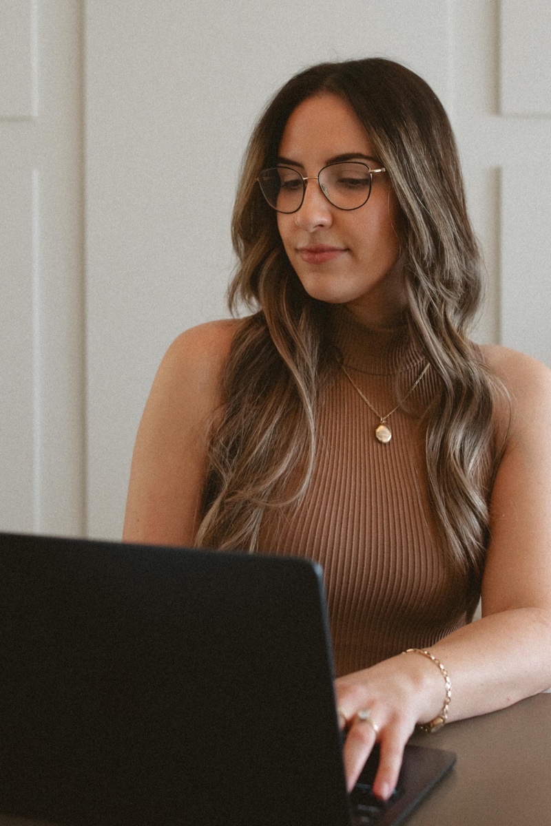 A therapist at a laptop in a calm room, evoking one-on-one online individual therapy at Anchor & Bloom