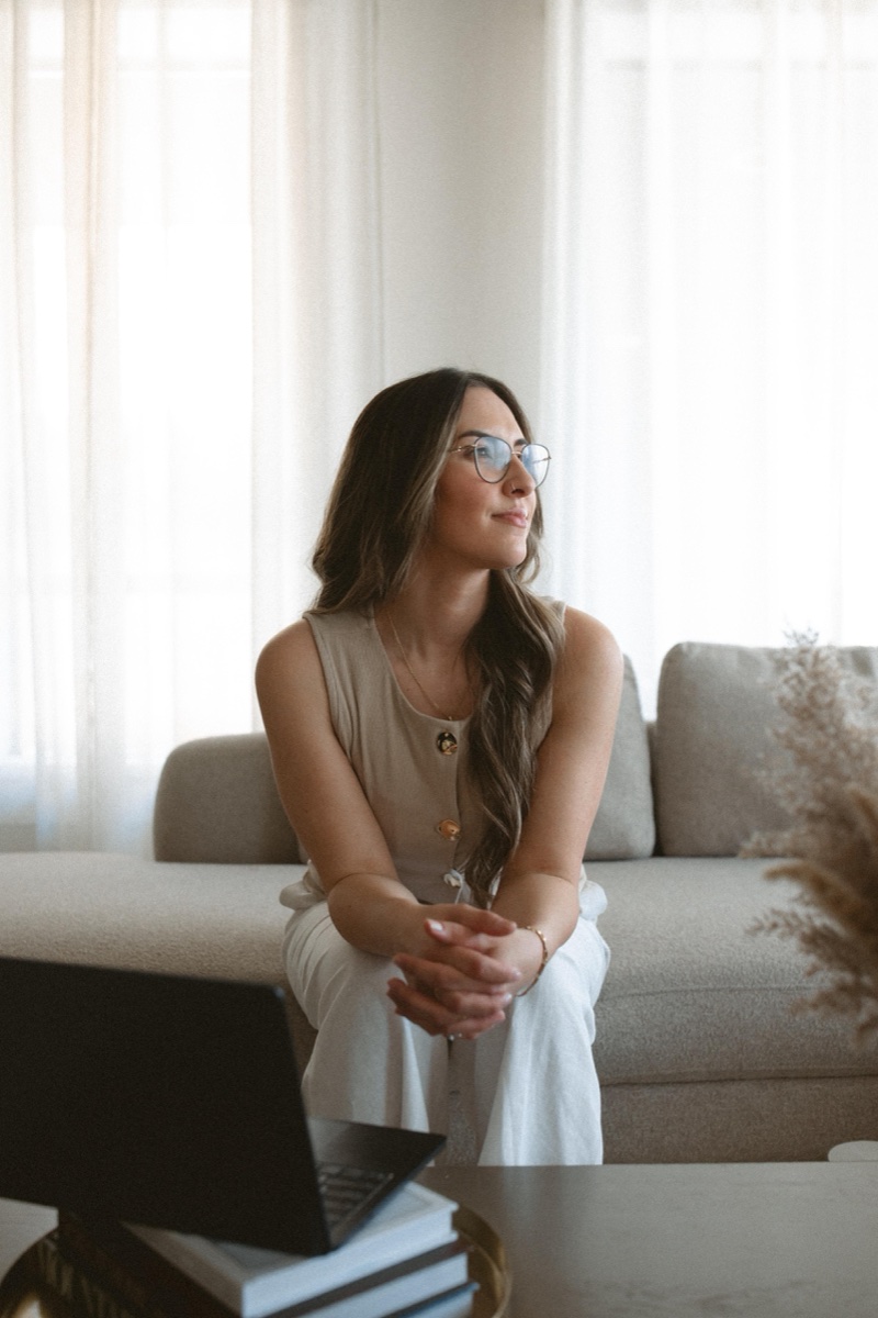 Katelyn Matias, RP, in a quiet moment of reflection on a couch in the Anchor & Bloom therapy space