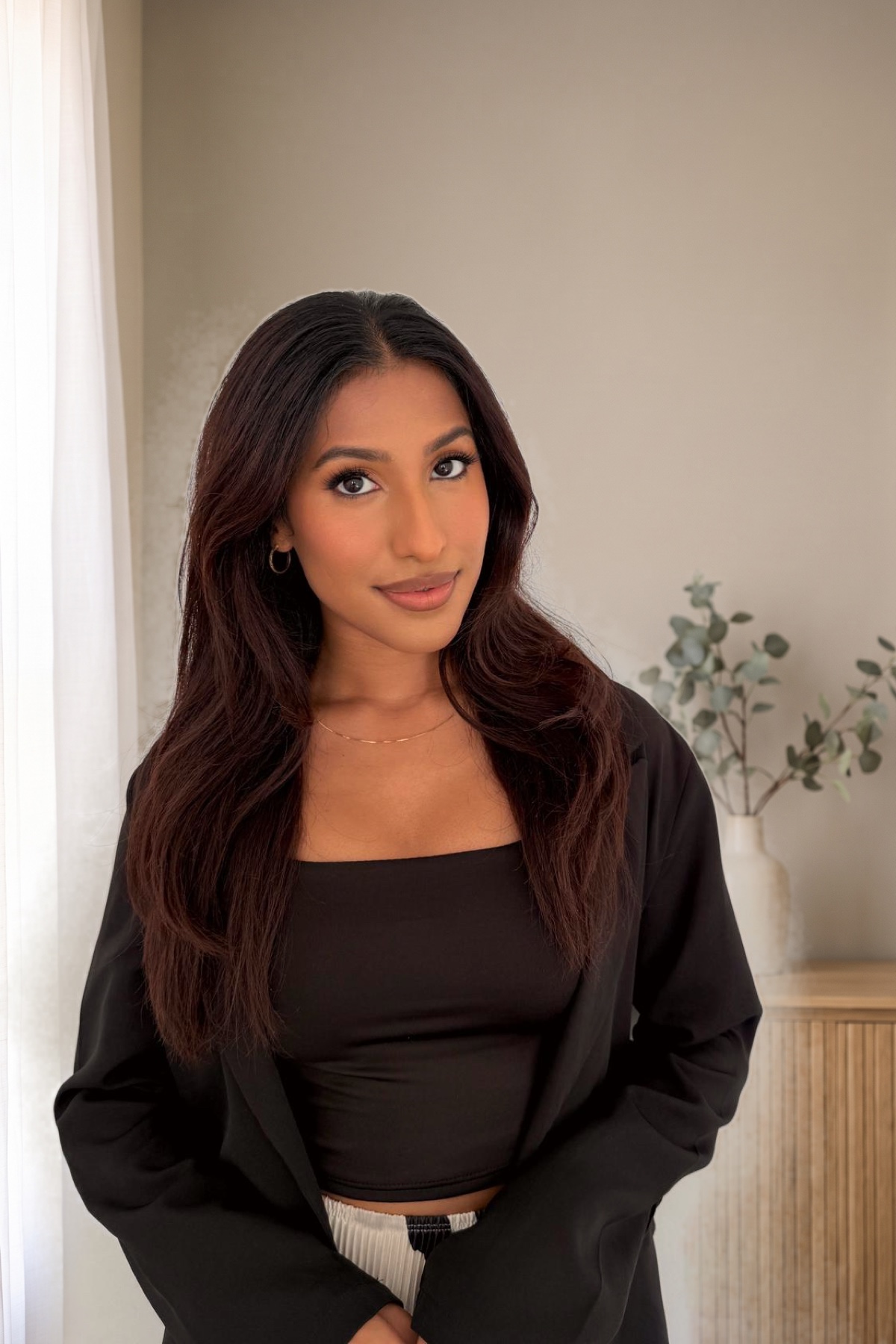 Mahima Chauhan, Registered Psychotherapist (Qualifying), standing portrait in a warm office setting
