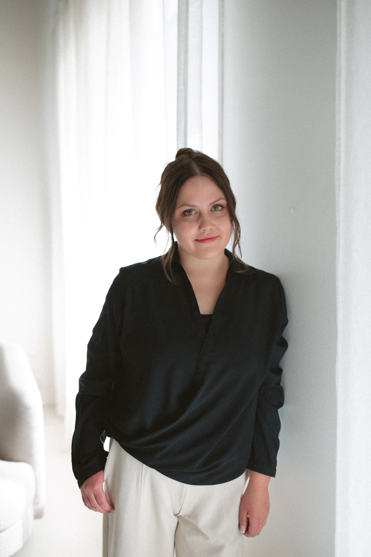 Megan Harvey standing beside a softly lit window
