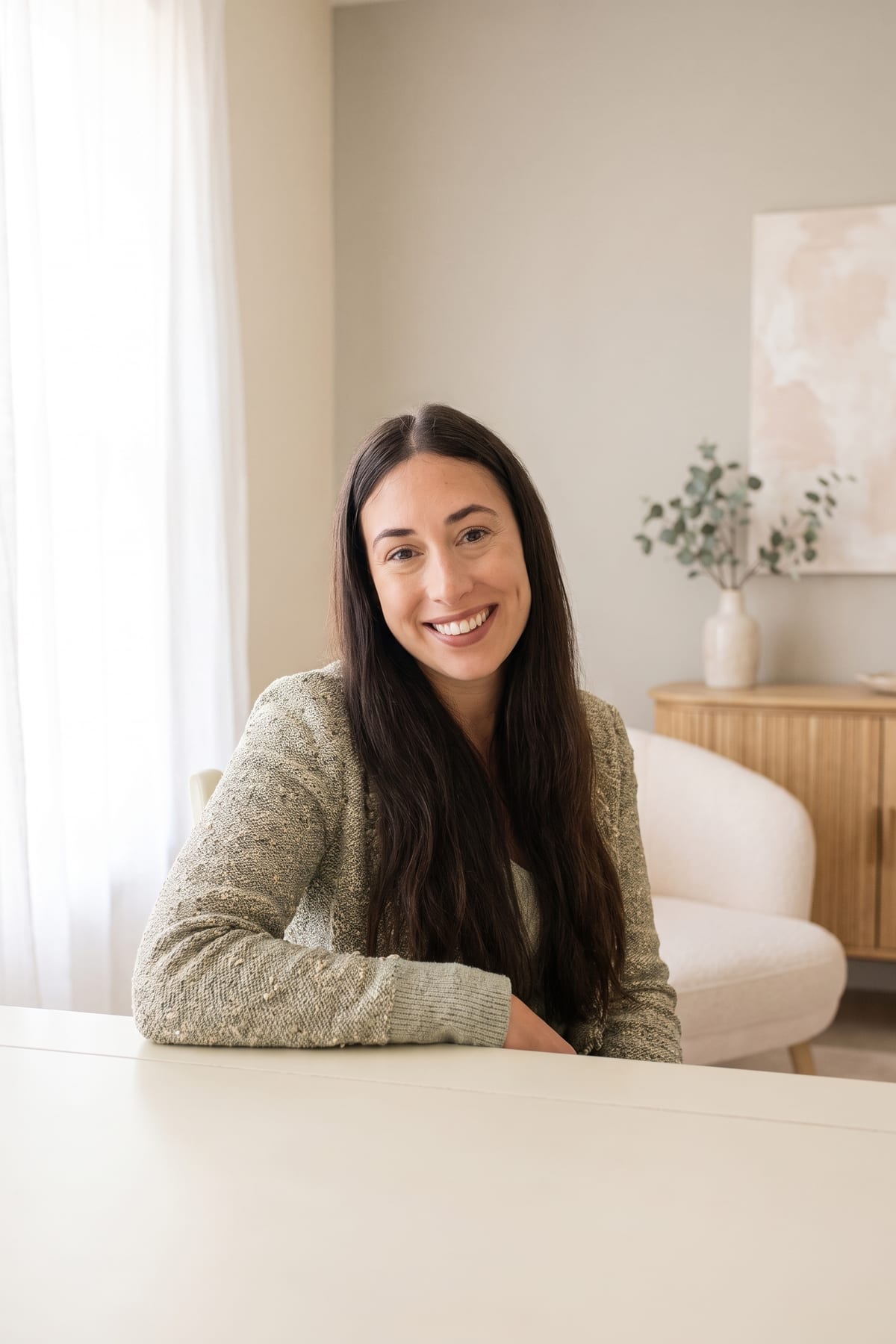 Natalie Besharat, Registered Psychotherapist (Qualifying), seated portrait in a therapy office