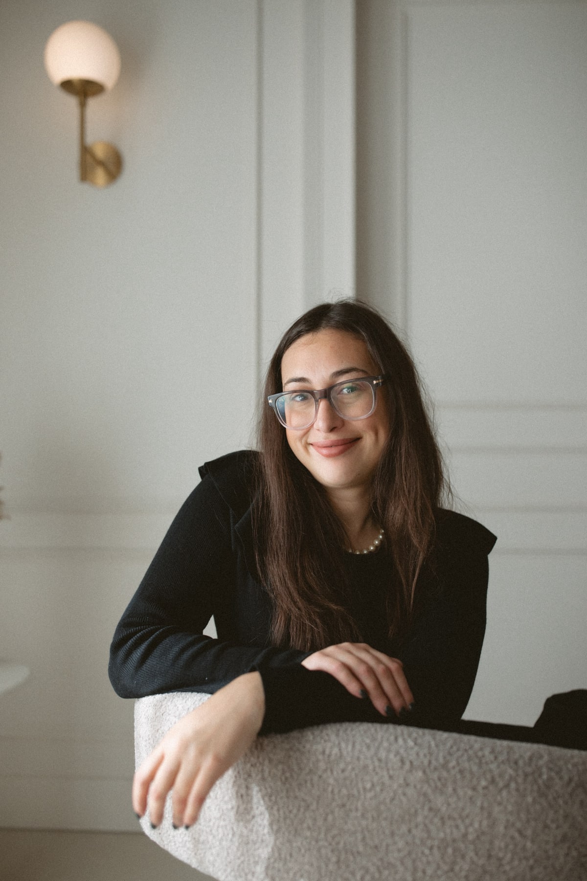 Natalie Besharat seated beside a chair