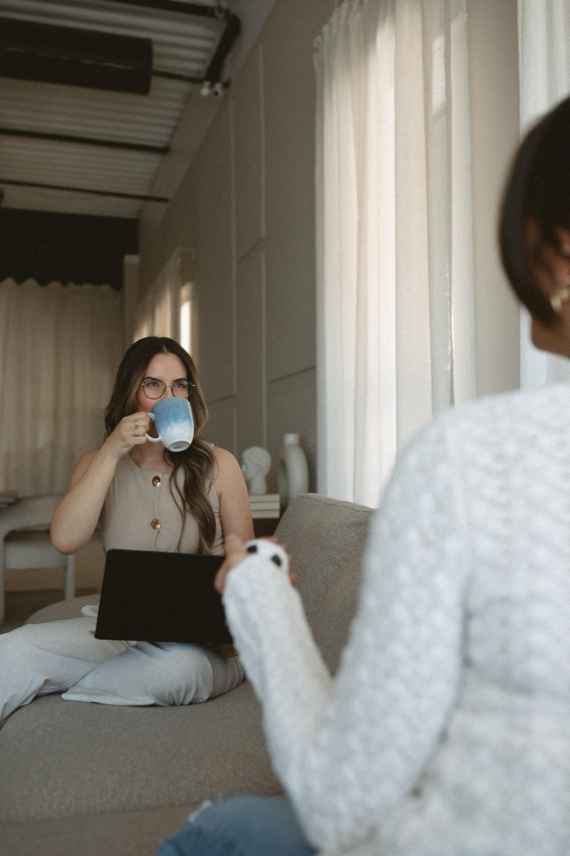 A warm consultation moment between Katelyn Matias and a client in the Anchor & Bloom therapy office